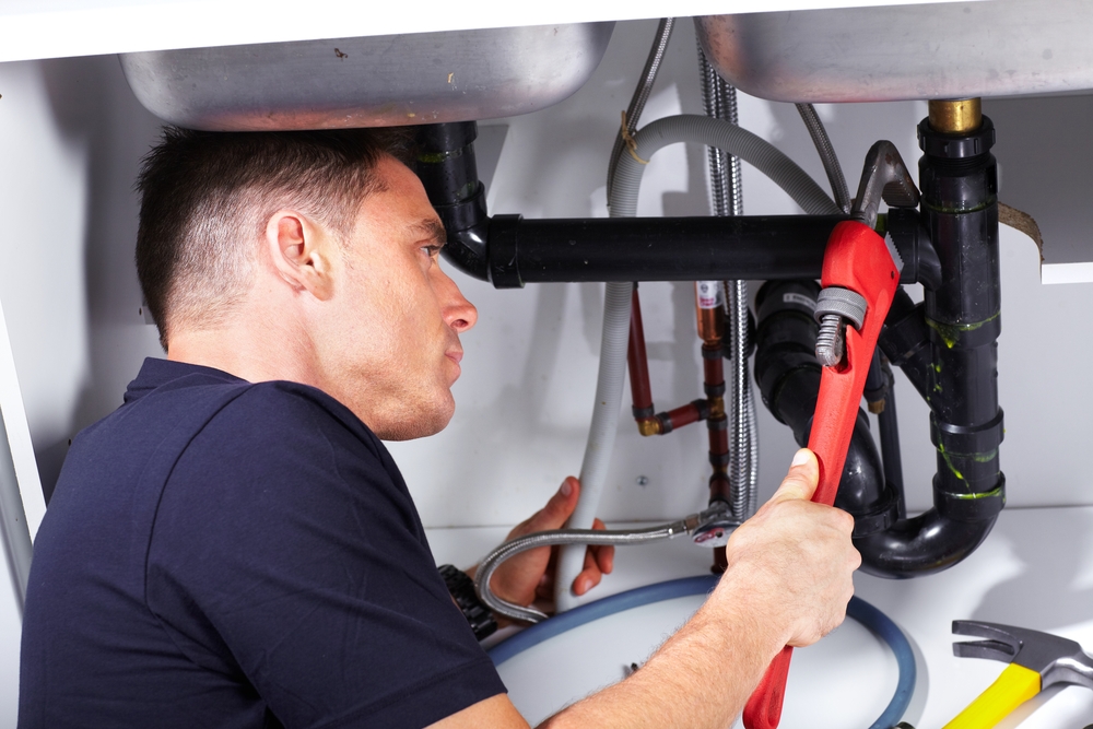 Certified plumber performing routine maintenance in Ada